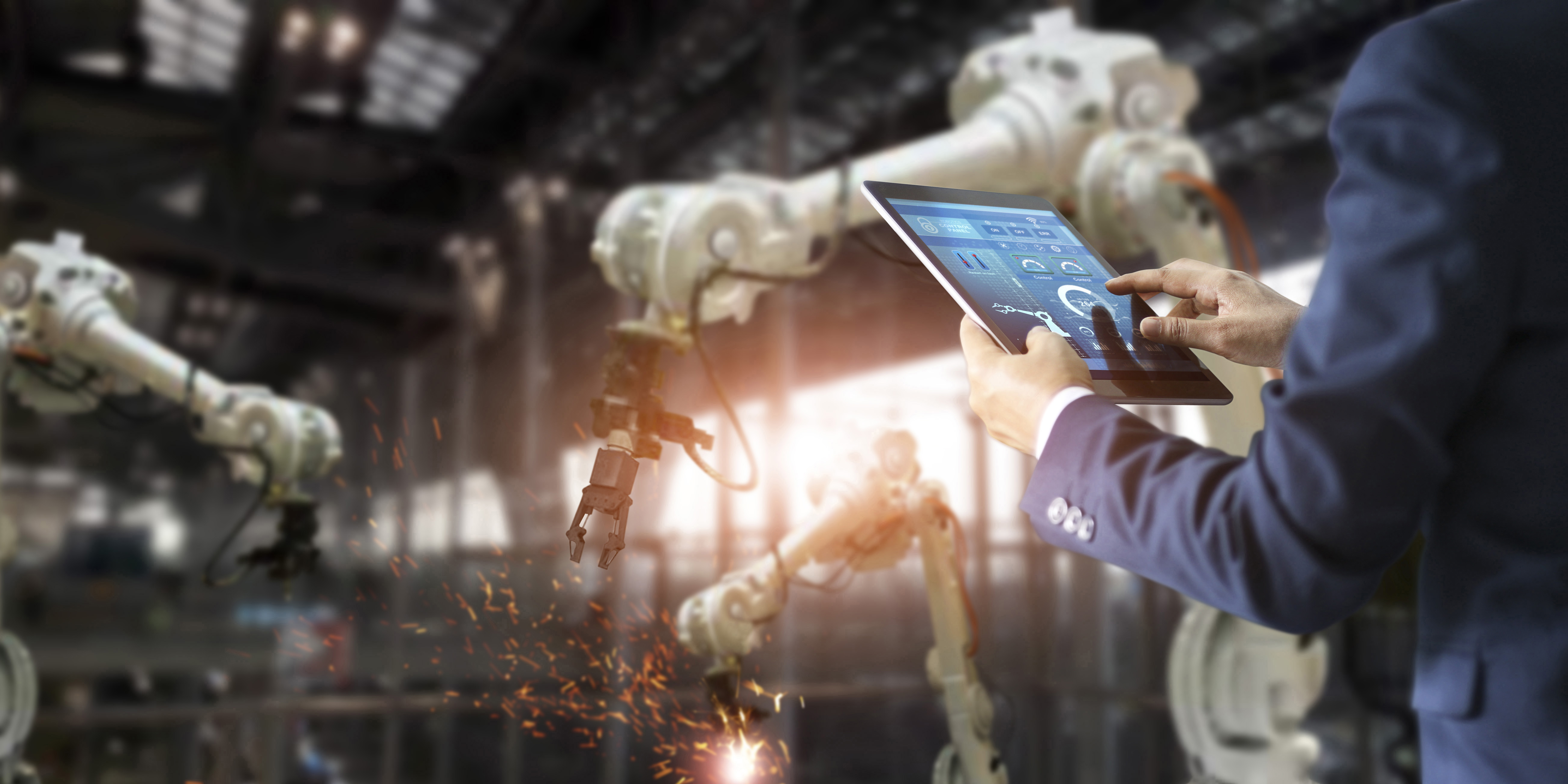 person using tablet to control robotic arm