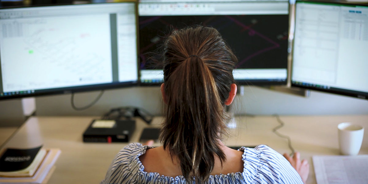 women in front of computer monitors