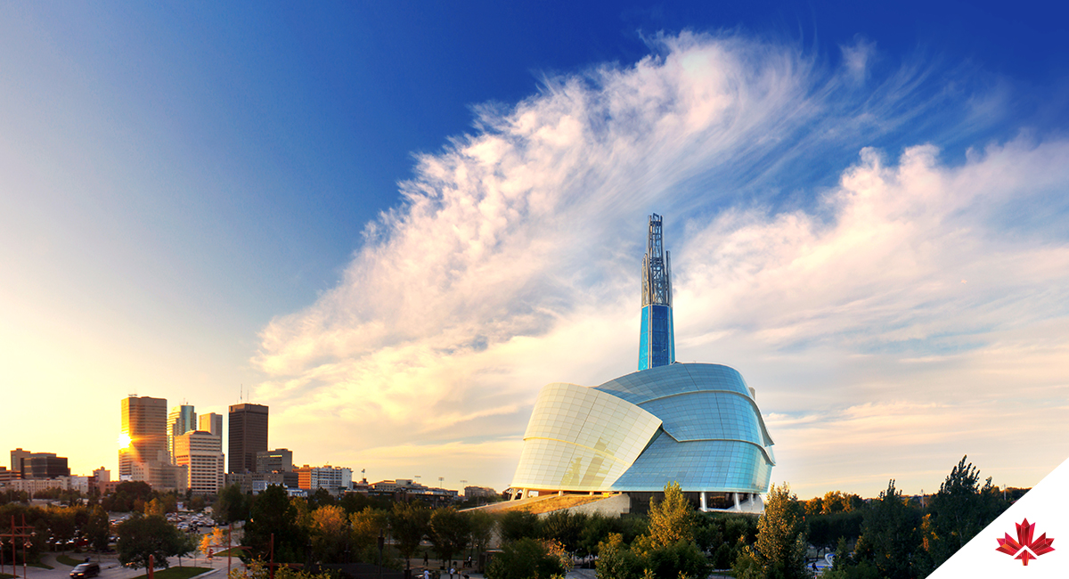 Sunset view of Winnipeg from The Forks, featuring the skyline and the Canadian Museum for Human Rights on the right.
