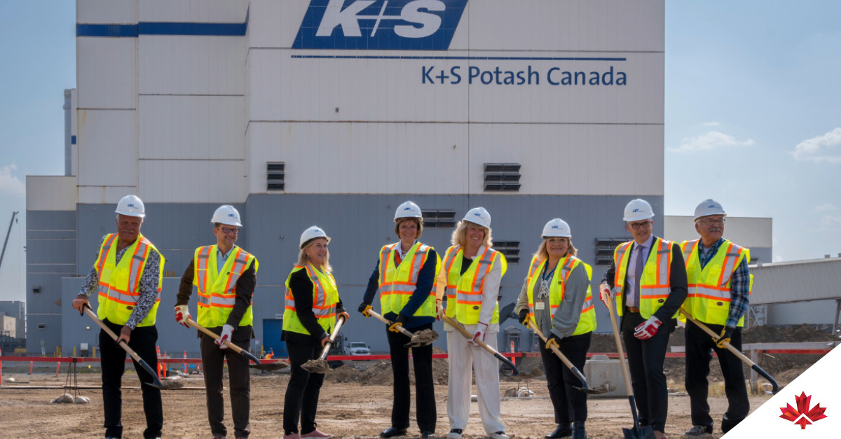 Eight people in safety gear stand with shovels in front of a building labeled "K+S Potash Canada," marking a groundbreaking ceremony. Invest in Canada’s CEO Laurel Broten is in the centre, fifth person from the left.