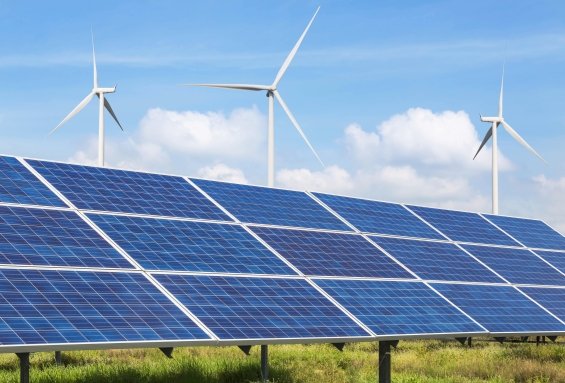 Solar panels and wind turbines at a power station producing clean renewable energy under a clear sky.