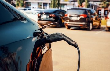 An electric car charging in a parking lot. 