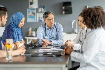 A group of diverse healthcare professionals in discussion, enhancing teamwork and collaboration in a hospital environment. 