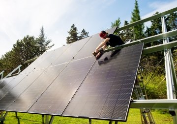A male solar installer assembling a ground mount solar array.