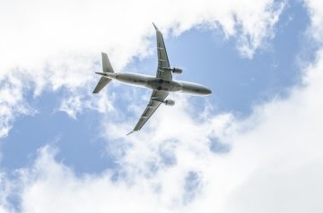 Commercial jet airplane flying during autumn day.