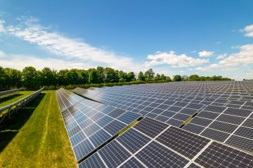 View of modern photovoltaic solar panels to charge battery. Rows of sustainable energy solar panels set up on the farmland.