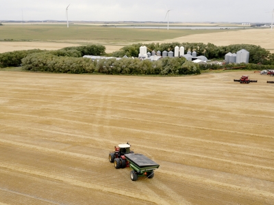 tractor driving in field towards farm